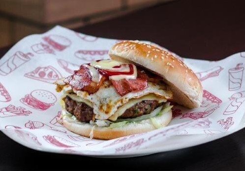 La misma hamburguesa en la foto original, sobre papel del local